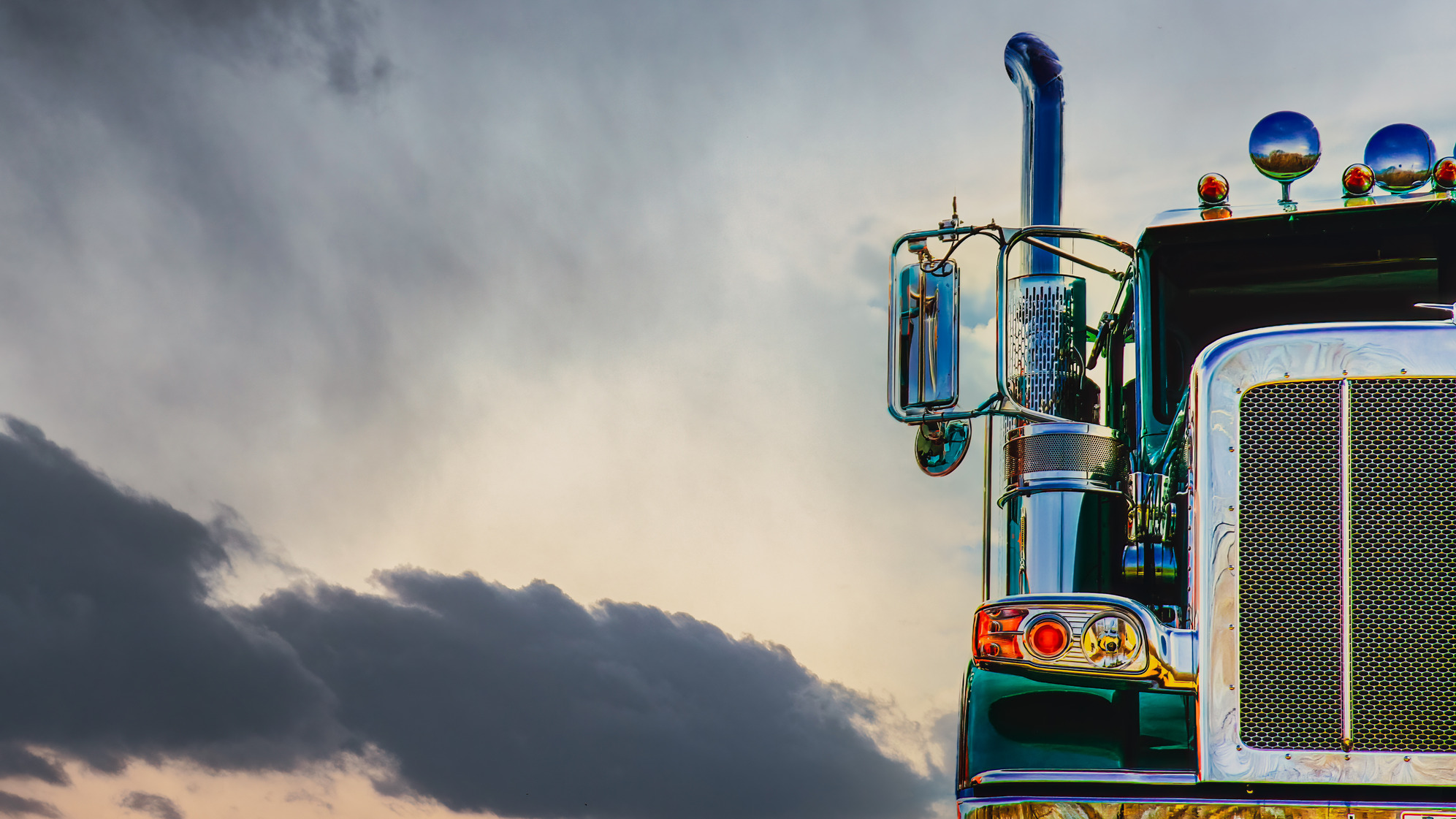 Frontal view of a semi truck against a grey cloudy background, symbolizing reliable auto transportation services.